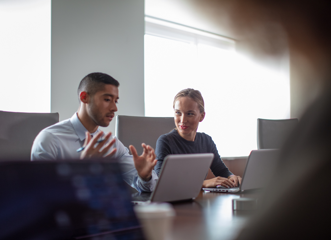 Two employees sitting and discussing business communication.